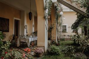 um pátio de uma casa com uma mesa e plantas em La Baronessa B&B em Riposto