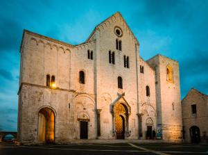 uma grande igreja de pedra com uma torre à noite em LAUS Teatro Petruzzelli Suite em Bari