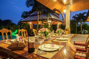 a table with a bottle of wine on top of it at Saifon Villas 3 Bedroom Pool Villa can also be rented as a 2 bedroom or 1 bedroom villa in Ao Nang Beach