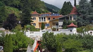 un groupe de maisons sur une colline plantée d'arbres dans l'établissement Ferienwohnungen Garten Eden, à Trebesing