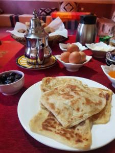 a plate of food with pancakes on a table at Auberge Kasbah Ait Marghad in Tamellalt