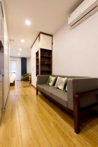 ein Wohnzimmer mit einem Sofa in einem Zimmer in der Unterkunft Nexy Living in Hanoi