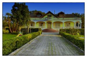 a large yellow house with a cobblestone road in front at Villa Costiera Salerno in Salerno