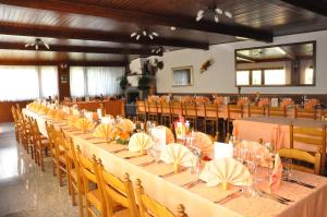 un gran salón de banquetes con mesas y sillas largas en Hotel Bellavista, en Teglio