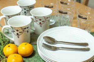 a table with plates and utensils and cups and oranges at 札幌市中心部大通公園まで徒歩十分観光移動に便利なロケーションs1111 in Sapporo