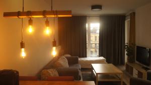 Art Apartment Szczecin II في شتتين: غرفة معيشة مع أريكة وطاولة