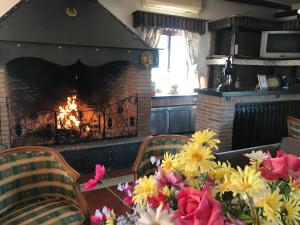 una chimenea en la sala de estar con flores frente a ella en Cortijo Salinas, en Montecorto