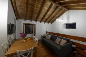 Casa Rural Los Frailes في Los Llanillos: غرفة معيشة مع أريكة وطاولة