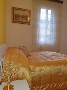 a bedroom with a gold bed with a window at Liluna in Bologna