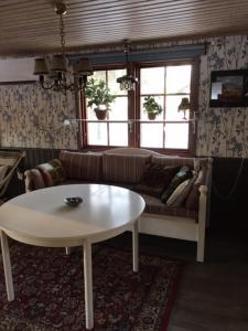uma sala de estar com uma mesa e um sofá em Rödberget em Råneå