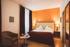 a hotel room with a bed and a chair at Heritage Hotel Hallstatt in Hallstatt