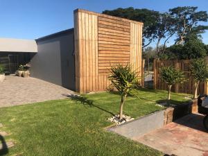 a backyard with a wooden fence and grass at RElaxed city living in Port Elizabeth