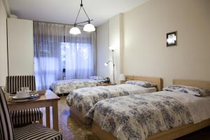 Zimmer mit 3 Betten und einem Tisch in der Unterkunft Santa Croce in Rom