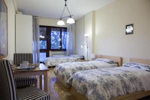 1 Schlafzimmer mit 3 Betten und einem Tisch mit einem Stuhl in der Unterkunft Santa Croce in Rom
