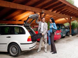 two people standing next to a parked car at Sporthotel Schieferle in Innsbruck