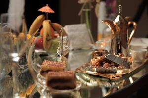 a glass table with a plate of desserts on it at Sharz Hotel in Buraydah