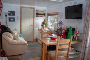 ein Wohnzimmer mit einem Tisch und einem TV in der Unterkunft Room with a view in Spean Bridge