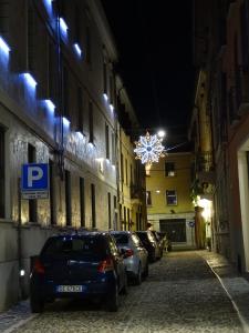 Una calle por la noche con coches aparcados en la calle en Suite Alcova en Mantova
