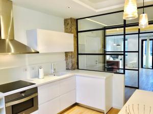 une cuisine avec des placards blancs et une grande fenêtre dans l'établissement Hauzify I Apartamento Ruiz de Padron, à San Sebastián de la Gomera