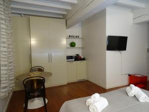 a room with two beds and a table and a tv at Suite Alcova in Mantova