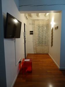 pasillo con TV de pantalla plana en la pared en Suite Alcova en Mantova