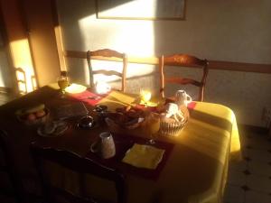 una mesa con comida y velas encima en L'Orme-Vial, en Saint-Galmier