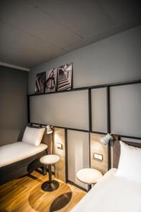 a room with two beds and two stools at ibis Wels in Wels