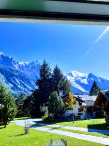 una vista da una finestra di una casa con montagne di Le Bivouac a Chamonix-Mont-Blanc