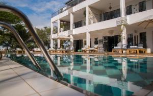 a swimming pool in front of a building at Latitude 0 Degrees in Kampala