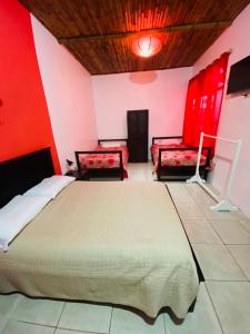 a bedroom with a large bed and red walls at Zurisadai in Puerto Ayora