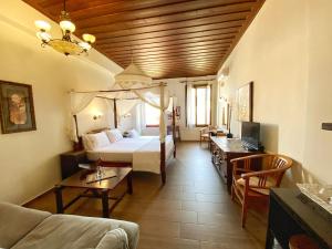 ハニア・タウンにあるBoutique Hotel Del Dogeのベッドとリビングルームが備わるホテルルームです。