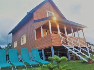 een huis met blauwe stoelen ervoor bij Agrodomki Okej-Biały Dom in Gardna Wielka