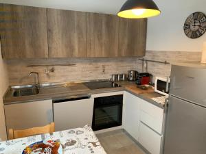 a kitchen with a sink and a refrigerator and a table at White Rock in Ponte di Legno +16 photos