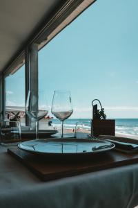 a table with two wine glasses and a view of the ocean at Hotel Tirreno in Latina