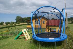 um parque infantil com escorrega e um baloiço em Agrodomki Okej-Biały Dom em Gardna Wielka
