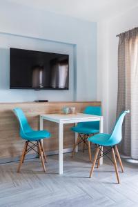 ein Wohnzimmer mit einem Tisch und 2 blauen Stühlen in der Unterkunft Okean Studios in Ierissós