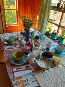 una mesa con platos y cuencos encima en Hostal La Casa del Carpintero en Coñaripe