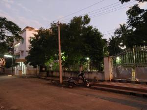 a scooter parked on the side of a street at night at Mayurapriya Inn in Chennai