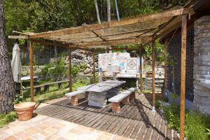 pérgola de madera con banco y mesa de picnic en Villetta Simonetta, en Maccagno Superiore