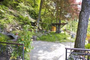 Un jardín con un camino de piedra y un árbol. en Villetta Simonetta, en Maccagno Superiore