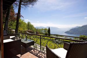 balcón con mesa y sillas y vistas al lago en Villetta Simonetta, en Maccagno Superiore