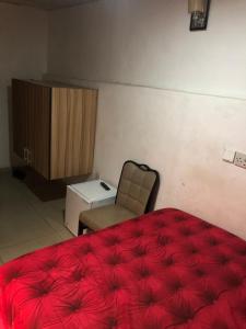 1 dormitorio con 1 cama roja y 1 silla en DE’ BAKERS SUITES, en Lagos