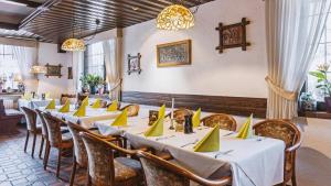 eine Reihe von Tischen in einem Restaurant mit gelben Servietten in der Unterkunft Hotel Restaurant Menden in Menden