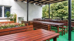 un ensemble de bancs et de tables en bois sur une terrasse dans l'établissement Hotel Restaurant Menden, à Menden