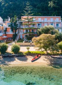 a boat on the beach in front of a resort at Anna Apartments Boukari in Boukari