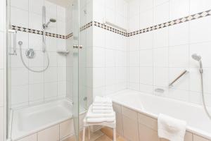 een witte badkamer met een bad en een douche bij Haus Lupfer in Oberstdorf