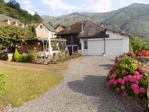 a house with a garage and flowers in the yard at Maison bigourdane in Ayzac-Ost