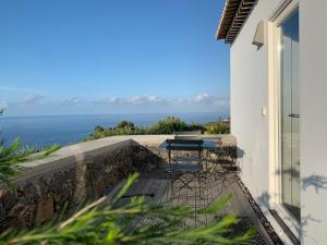 balcone con tavolo e vista sull'oceano sullo sfondo di Antiga Fábrica de Chá a Nordestinho