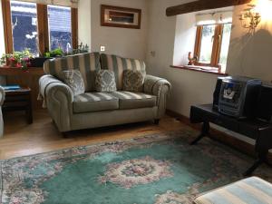 a living room with a couch and a television at The Orangery in Thurning