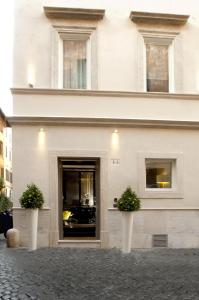 a white building with two potted plants in front of it at Mood44 in Rome